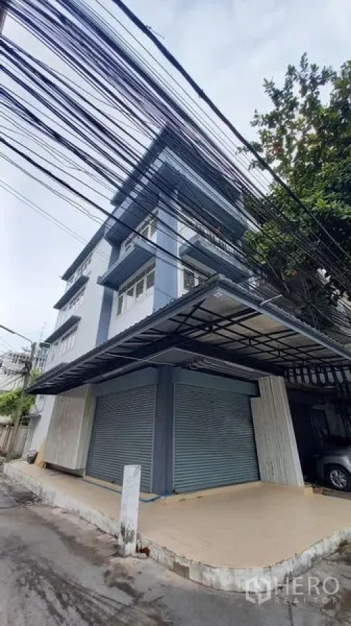 Shophouse for rent in Bangkok - Street-side view of shophouse with wide canopy roof and twin shutters.