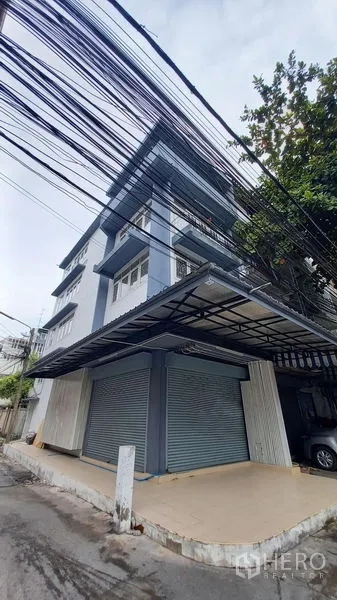 Shophouse for rent in Bangkok - Street-side view of shophouse with wide canopy roof and twin shutters.