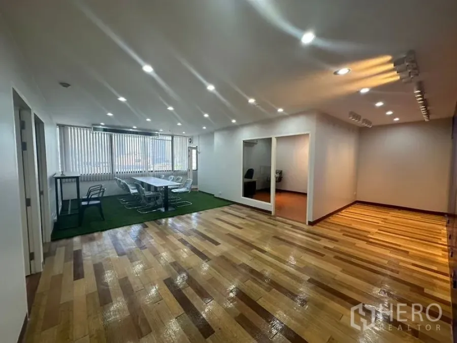 办公空间 出租在Yan Nawa, Bangkok - 开放式办公区，木地板，绿色地毯上的长会议桌与两间隔断房。