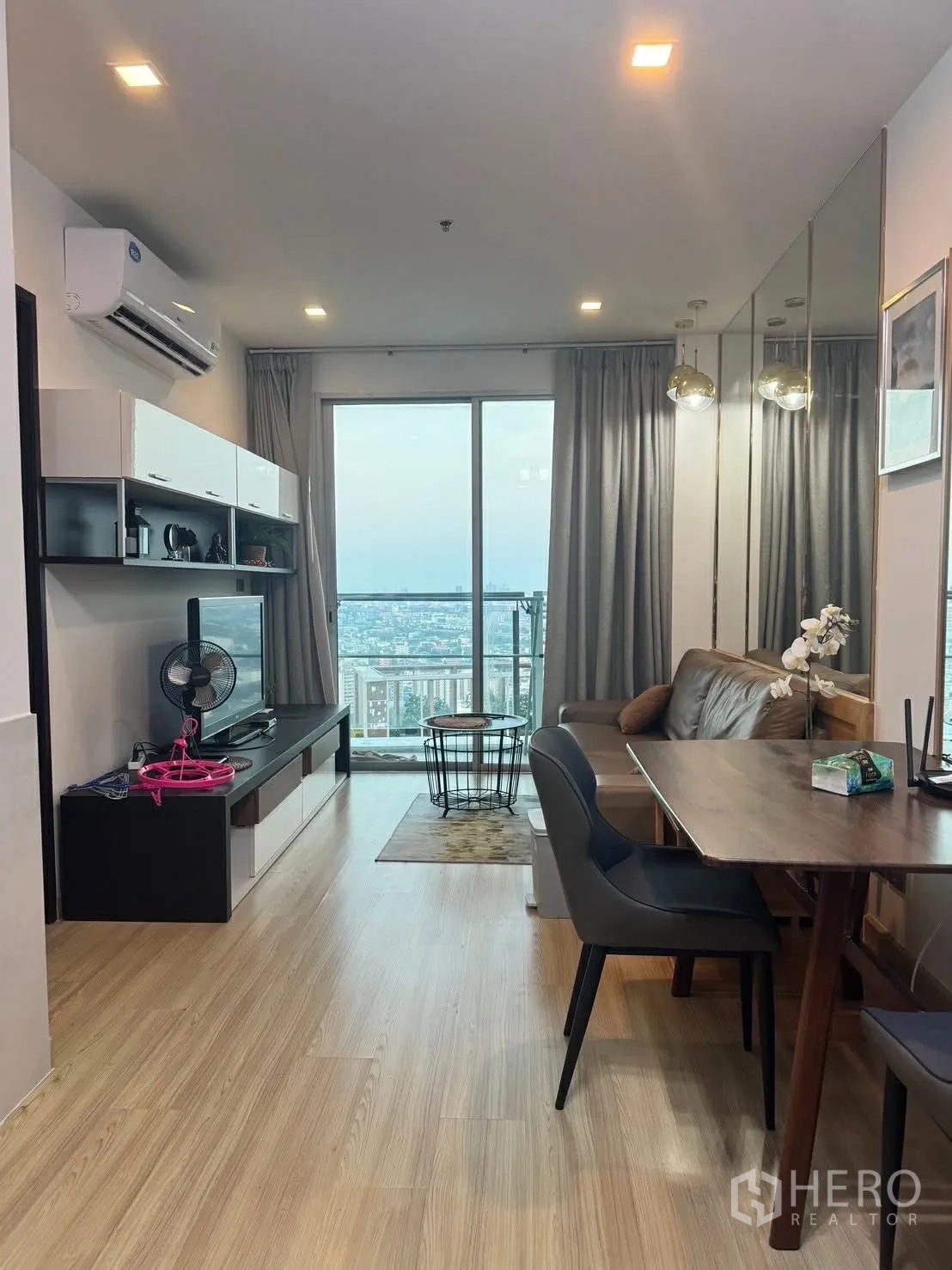 คอนโด for rent in Watthana, Bangkok - ห้องนั่งเล่นและรับประทานอาหารแบบเปิดโล่งพร้อมทีวี โซฟาหนัง และประตูระเบียงชมวิวเมือง