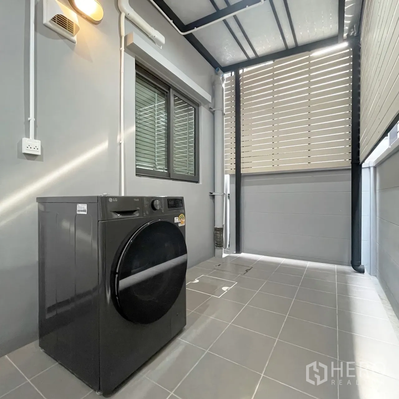 联排别墅 for rent in Bang Phli, Samut Prakan - 后院带顶棚的洗衣区，配前开门洗衣机与百叶隔板