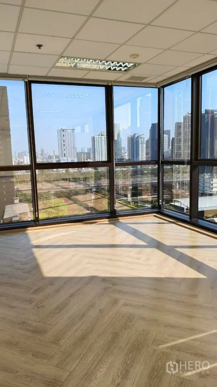 สำนักงาน for rent in Ratchathewi, Bangkok - ภาพแนวตั้งของมุมกระจก แสงแดดส่องบนพื้นไม้และวิวเมือง