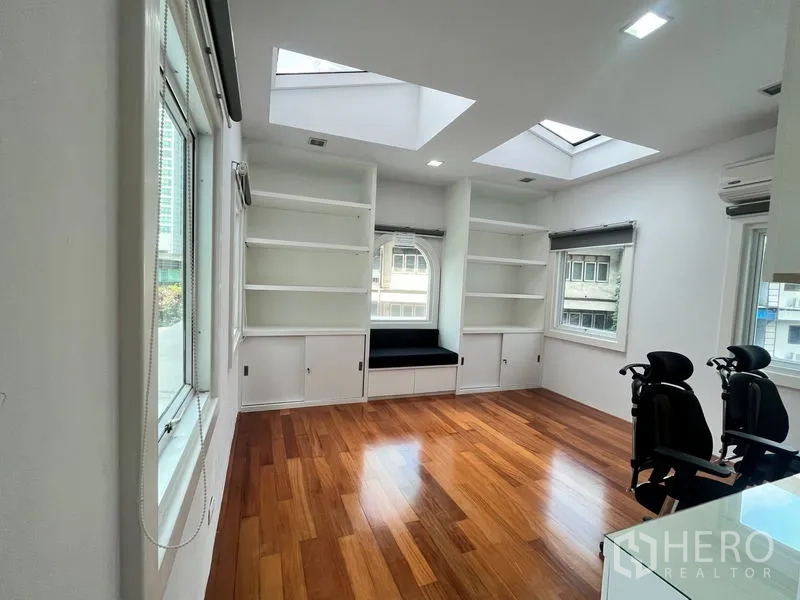 公寓 出租在Khlong Toei, Bangkok - 明亮书房，天窗与白色一体柜，木地板通透采光。