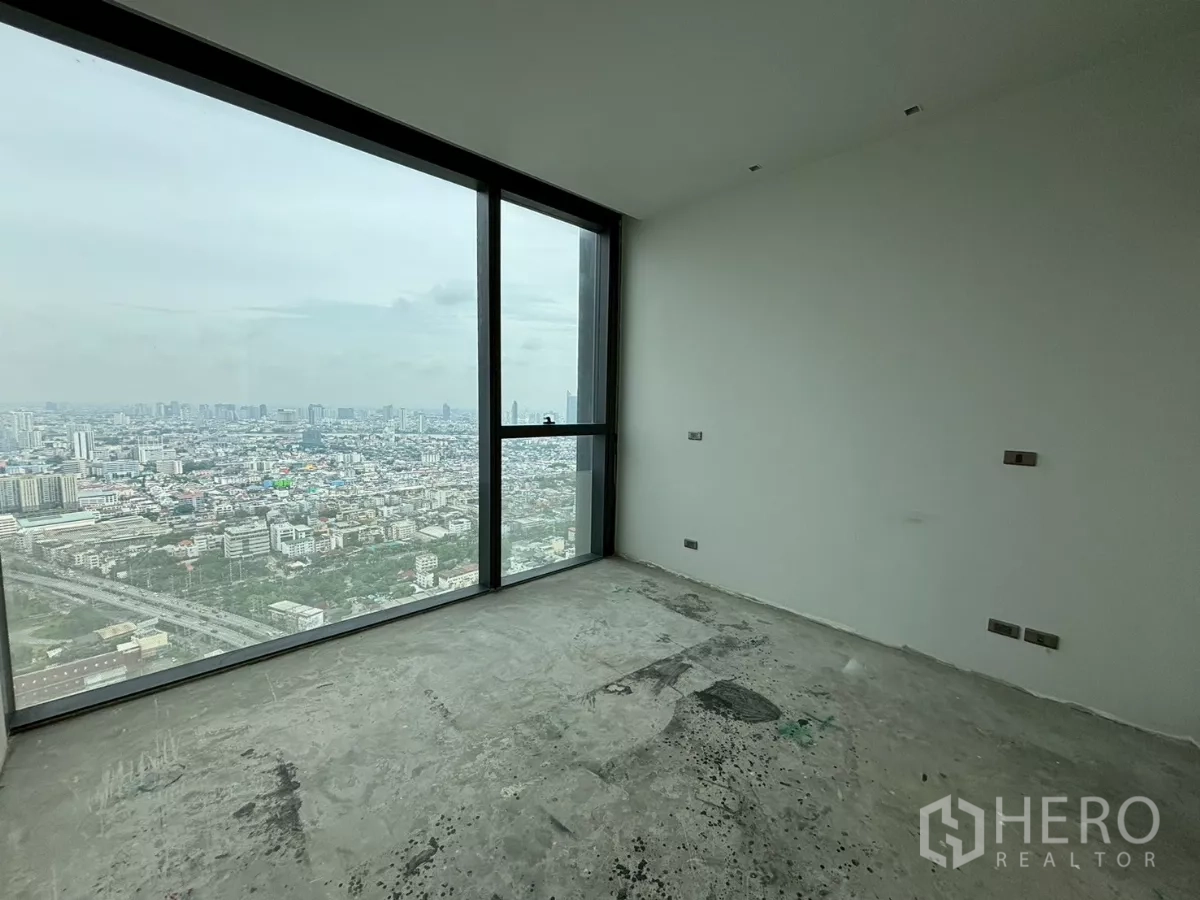 Condominium for sale in Bang Kho Laem, Bangkok - View through a doorway to two bright bedrooms with floor-to-ceiling windows over the city.