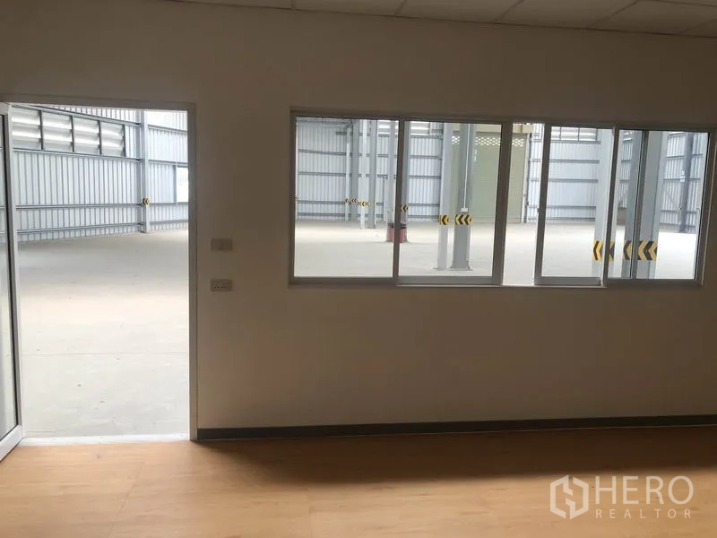 Warehouse for rent in Bang Yai, Nonthaburi - View from inside the office through sliding windows to the open warehouse floor.
