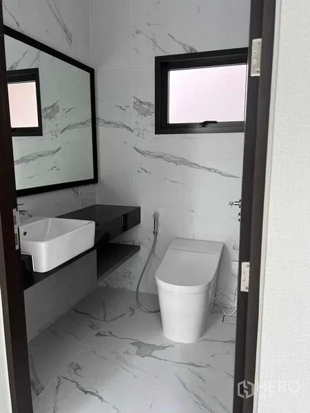 Detached House for sale in Bang Kruai, Nonthaburi - Compact powder room with white marble tiles and a window.