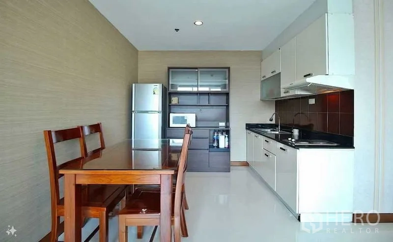 公寓 出售在Watthana, Bangkok - 开放式厨房，白色橱柜、黑色台面，木质餐桌与不锈钢冰箱。