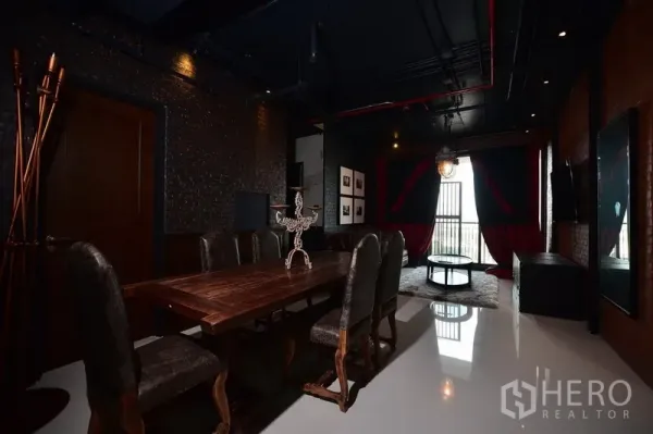 公寓 出租或出售在Khlong Toei, Bangkok - 宽敞餐区，长木桌与软包餐椅，黑色外露管线天花。