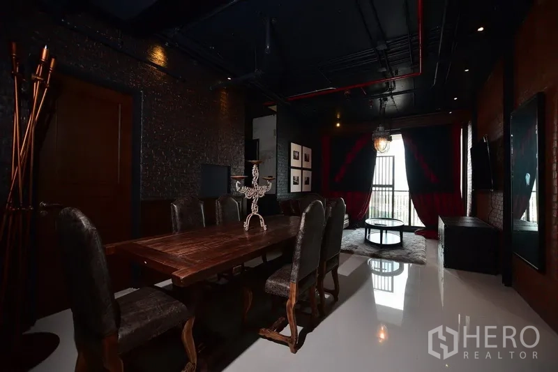 公寓 出租或出售在Khlong Toei, Bangkok - 宽敞餐区，长木桌与软包餐椅，黑色外露管线天花。