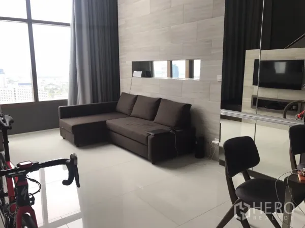 公寓 出租在Khlong Toei, Bangkok - 客厅拥有大幅窗景与转角沙发，loft风格视野通透。