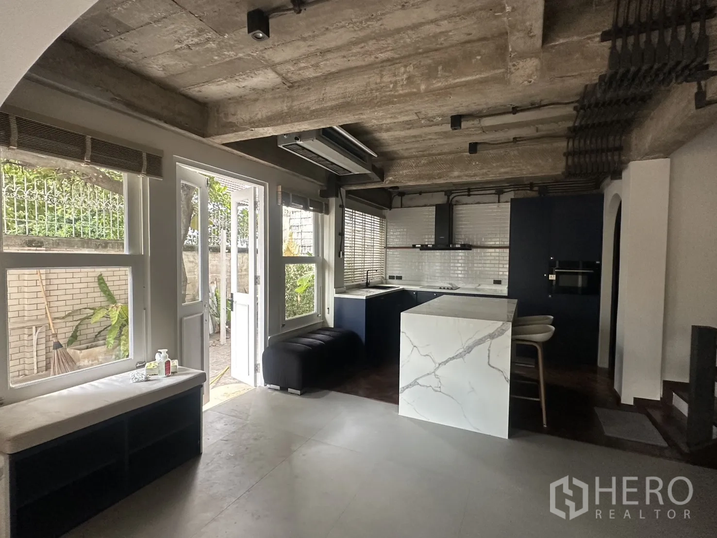 พื้นที่ขายของ for rent in Watthana, Bangkok - โซนครัวสมัยใหม่มีไอแลนด์หิน ประตูออกลาน และกระเบื้องซับเวย์สีขาว.