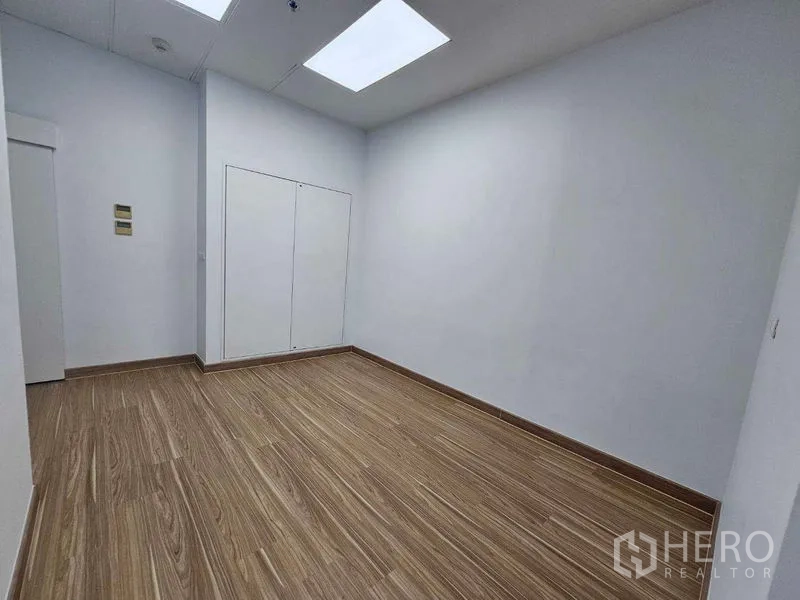 Office Space for rent in Sathon, Bangkok - Compact private office or storage room with wood-look flooring and white walls.