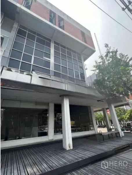 อาคารพาณิชย์ ให้เช่าหรือขายในKhlong Toei, Bangkok - มุมมองภายนอกอาคารหลายชั้น พร้อมระเบียงชานไม้และผนังกระจกบานใหญ่