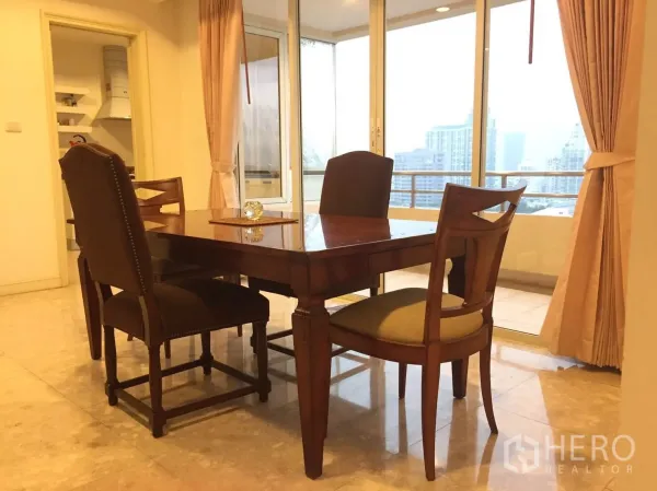 Condominium for rent in Watthana, Bangkok - Bright dining area with wooden table and chairs beside full-height windows and balcony city views.