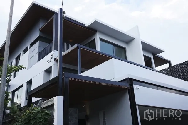 บ้านเดี่ยว for rent in Watthana, Bangkok - ภายนอกบ้านเดี่ยวสไตล์โมเดิร์น หน้าต่างบานใหญ่และระเบียง