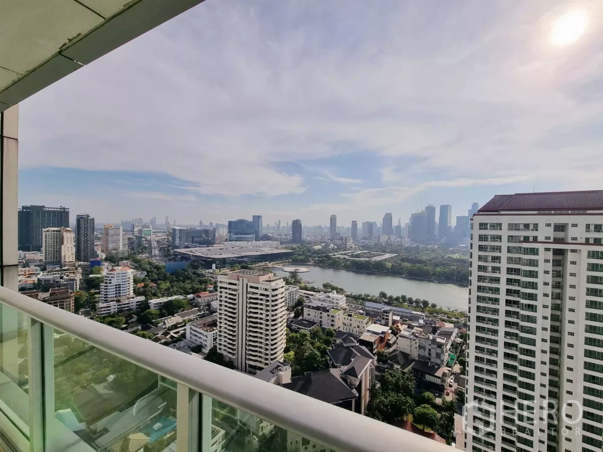 Condominium for rent in Khlong Toei, Bangkok - Balcony view of Benjakitti Park lake and Bangkok skyline from a high floor.