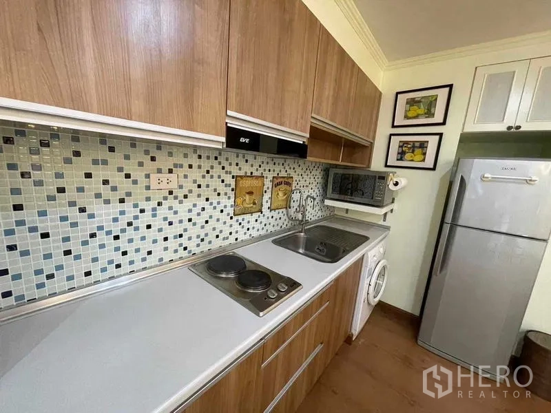Condominium for rent - Close-up of kitchen counter with cooktop, sink and mosaic tile backsplash.