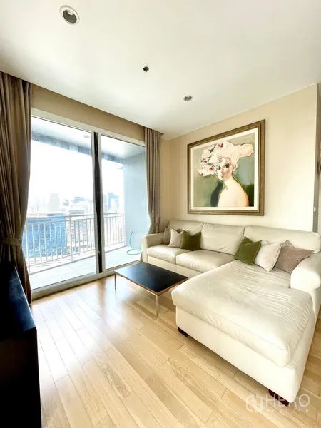 Condominium for rent in Watthana, Bangkok - Living room with sofa and sliding doors opening to a balcony city view.