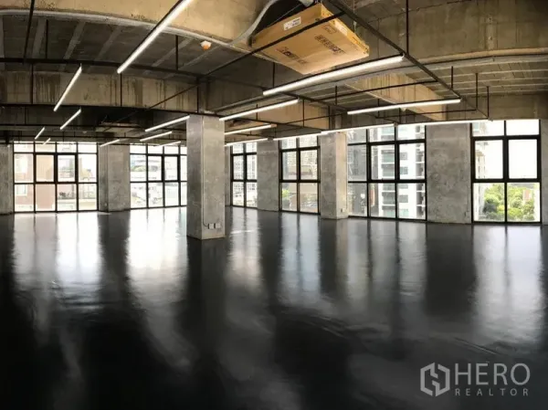 办公空间 出租在Khlong Toei, Bangkok - 开放式阁楼风办公室，黑色环氧地坪、裸露混凝土天花、线性LED灯，落地窗可览城市景观（Phrom Phong）。