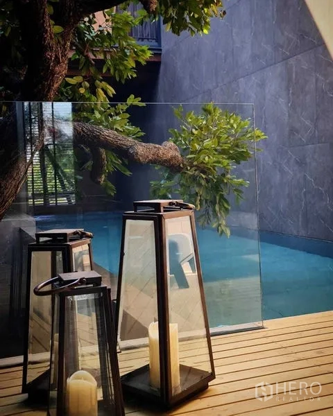 独立式住宅 出售在Lat Phrao, Bangkok - 木平台上的装饰灯笼，旁有玻璃护栏与蓝色泳池。