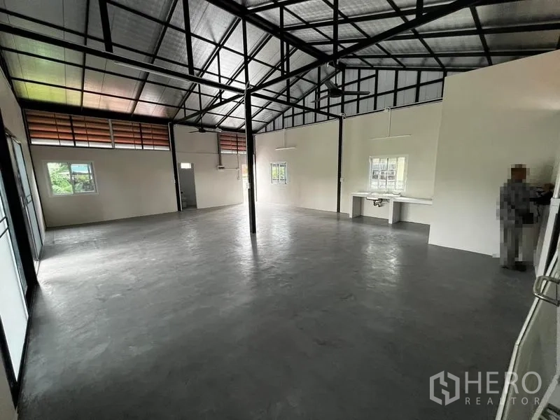货栈 出租在Suan Luang, Bangkok - 仓库内部通透空间，高钢架屋顶与抛光水泥地面。
