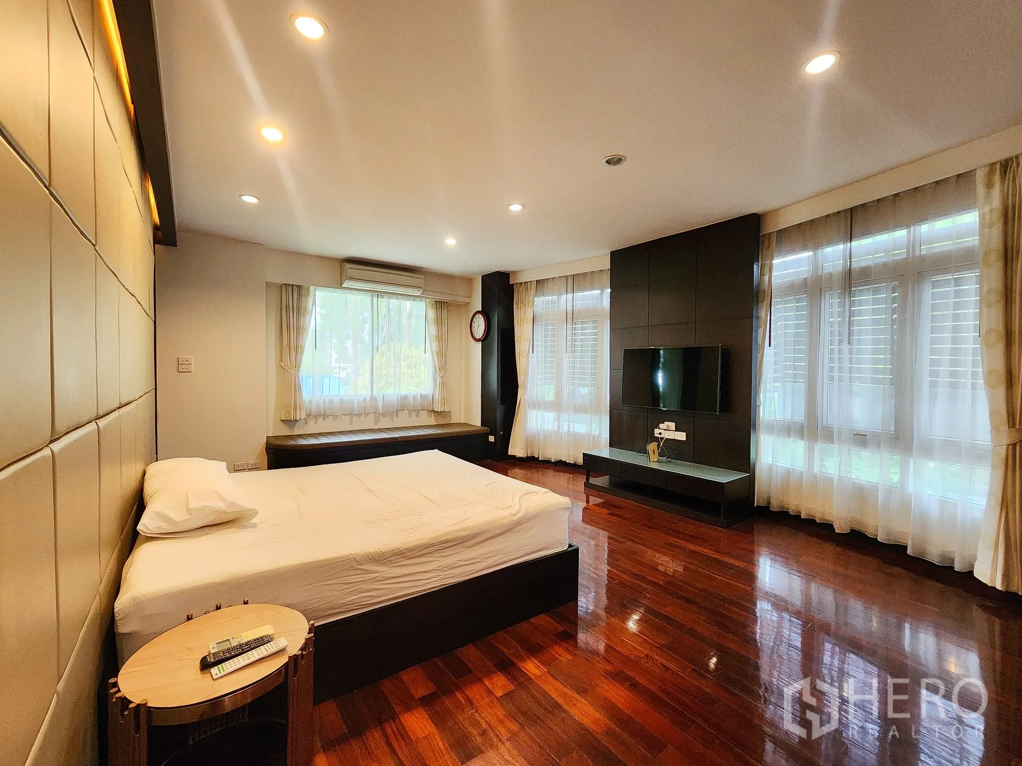 Detached House for rent in Bang Kapi, Bangkok - Master bedroom with padded accent wall and wraparound windows for natural light.