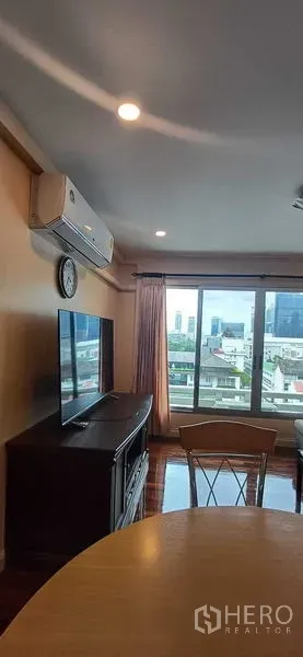 คอนโด ขายในPathum Wan, Bangkok - ห้องนั่งเล่นและรับประทานอาหารสว่างไสว พร้อมแอร์ ทีวี และหน้าต่างบานใหญ่เห็นวิวเมือง ย่านปทุมวัน กรุงเทพฯ