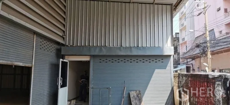货栈 出租在Huai Khwang, Bangkok - 侧立面可见卷闸门、金属围护与服务门，临小巷通道。