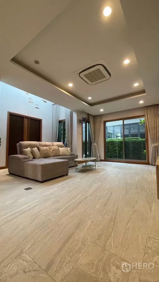 บ้าน ให้เช่าในPrawet, Bangkok - ห้องนั่งเล่นประตูกระจกบานเลื่อนมองสวนพุ่ม และโซฟา L‑shape