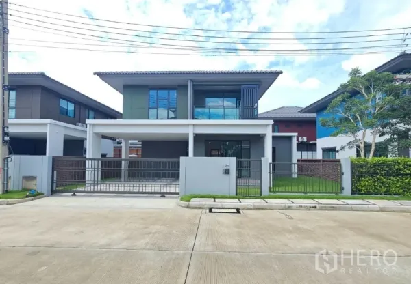Detached House for sale in Lam Luk Ka, Pathum Thani - Modern two-storey detached house exterior with gated driveway and lawn in Lam Luk Ka.