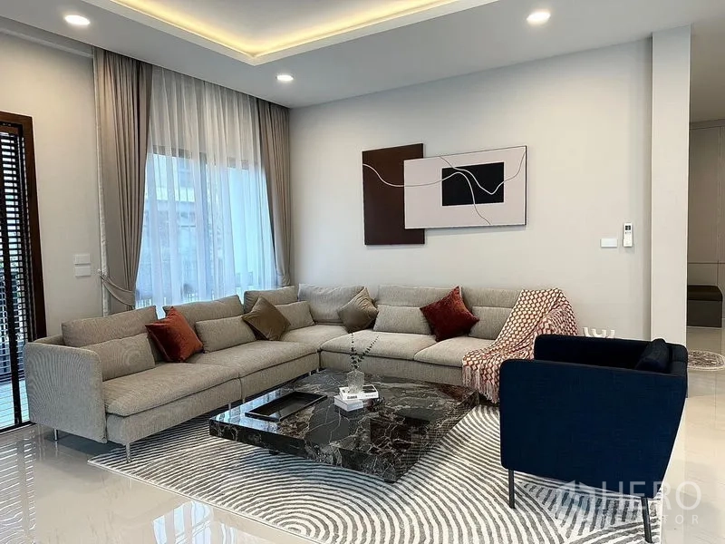 Detached House for rent or sale in Bang Phli, Samut Prakan - Contemporary living room with L-shaped sofa and marble coffee table.
