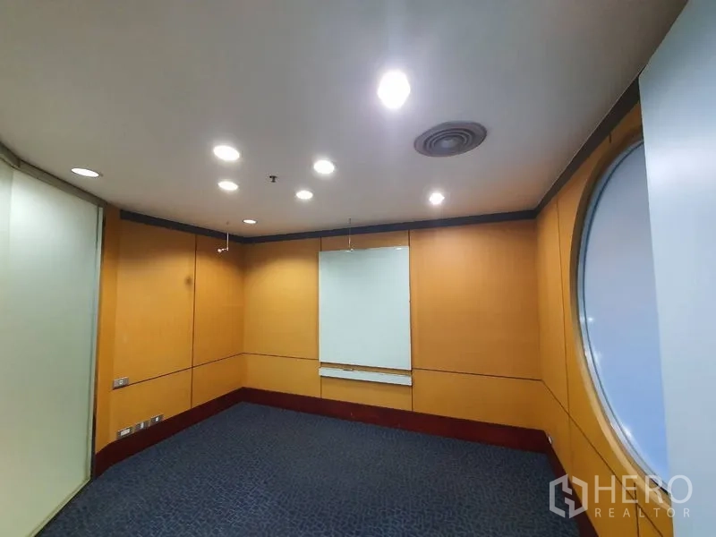 办公空间 出租在Watthana, Bangkok - 紧凑会议室，木质墙面、筒灯与圆形窗。