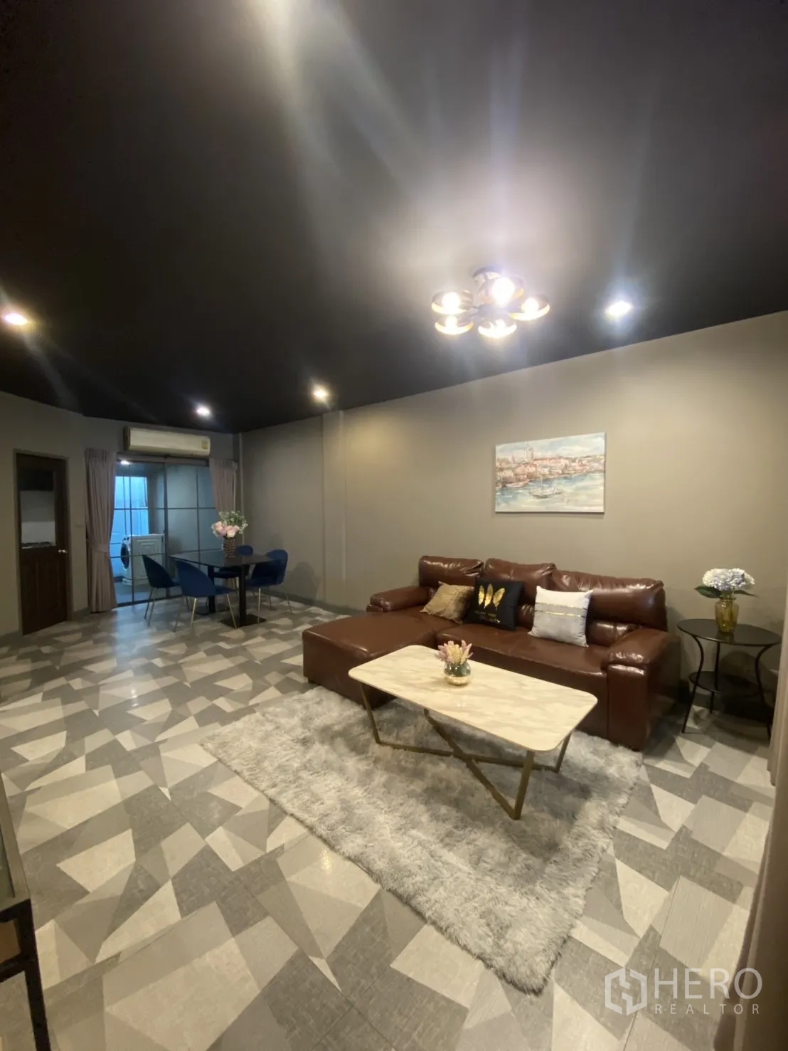 Townhouse for rent in Bang Kapi, Bangkok - Open-plan lounge and dining area with patterned floor tiles and recessed lighting.