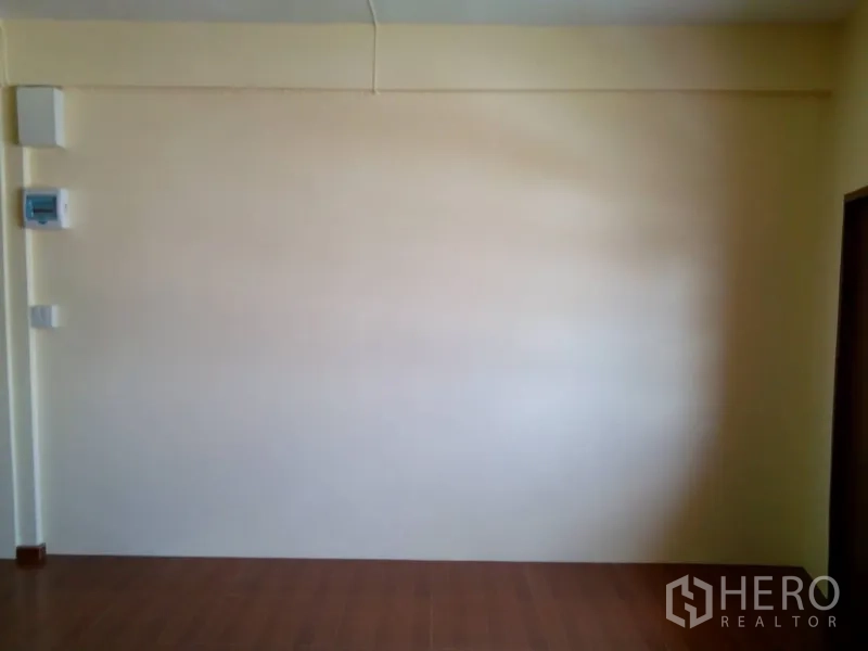 Shophouse for rent in Phra Khanong, Bangkok - Plain interior wall with electrical panel and light switches.