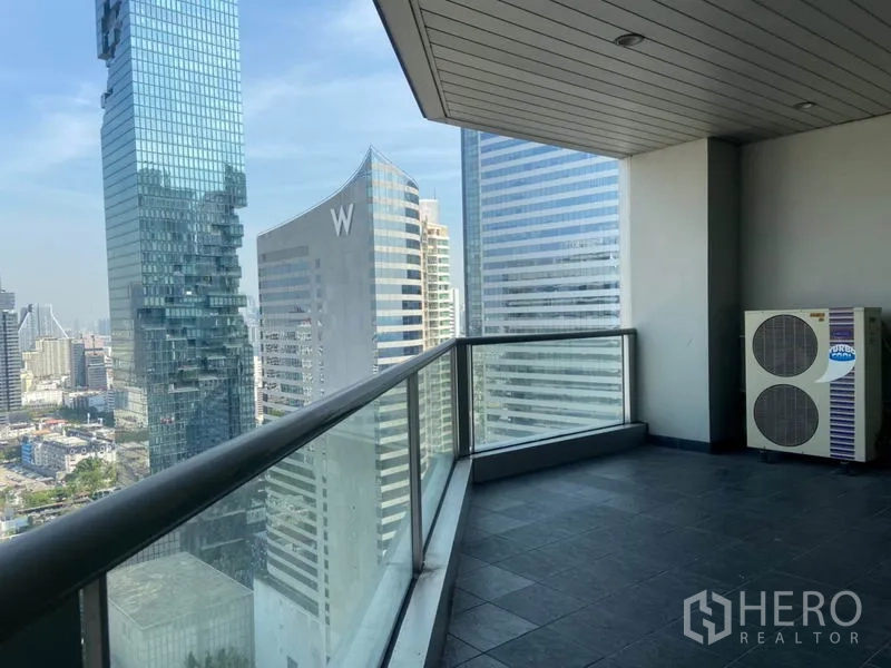 Condominium for rent in Sathon, Bangkok - Large covered balcony with glass railing offering Sathorn skyline city views.