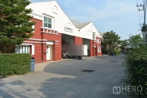 Warehouse for rent in Samut Sakhon - Red and white warehouse exterior with large roller shutter loading bays.