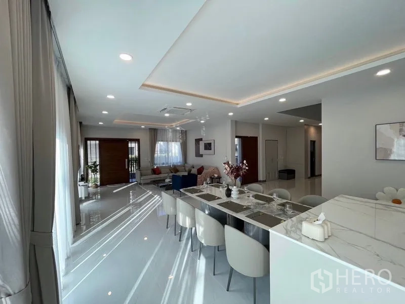 Detached House for rent or sale in Bang Phli, Samut Prakan - View from kitchen island across long dining table to living zone.
