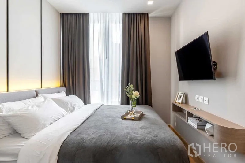 คอนโด ให้เช่าในWatthana, Bangkok - ห้องนอนมีทีวีติดผนัง ผ้าม่านสูง และหน้าต่างเต็มบาน