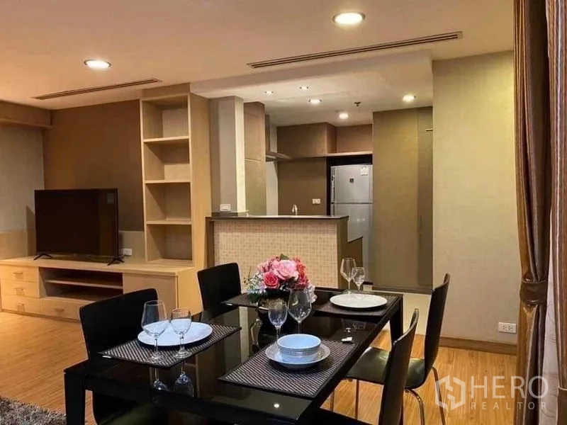 Condominium for rent in Watthana, Bangkok - Open‑plan dining and kitchen with four-seat table, TV unit and breakfast counter.