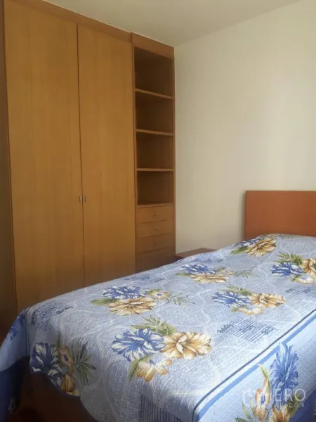 Condominium for rent in Khlong Toei, Bangkok - Second bedroom featuring a large wardrobe, open shelving and a double bed with a blue floral duvet.
