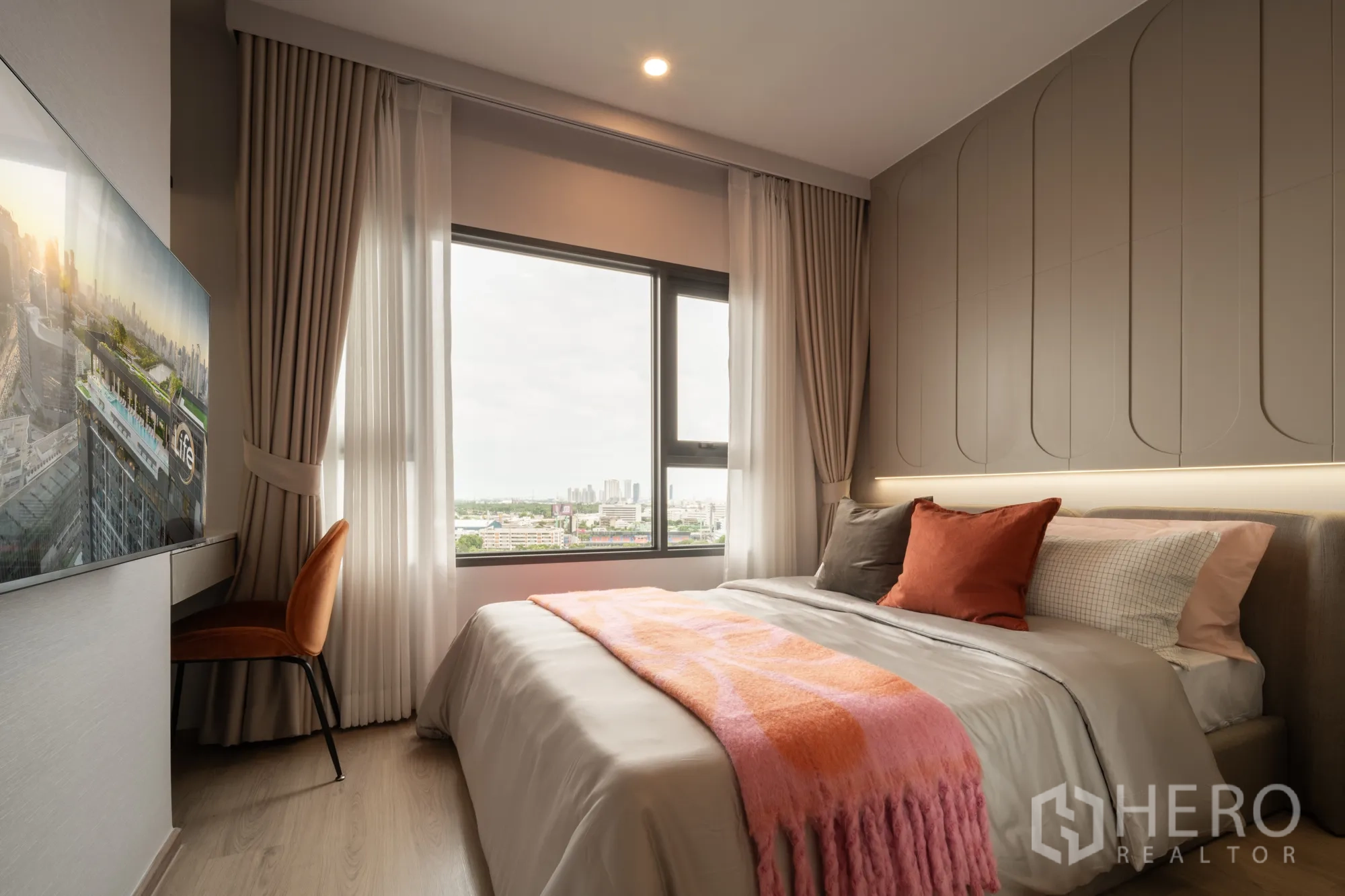 Condominium for sale in Khlong Toei, Bangkok - Cozy second bedroom with accent wall panels, desk by the window, and city outlook.