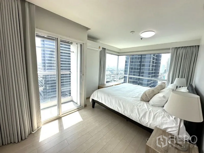 Condominium for rent or sale - Corner master bedroom with floor-to-ceiling windows and balcony access overlooking the city.