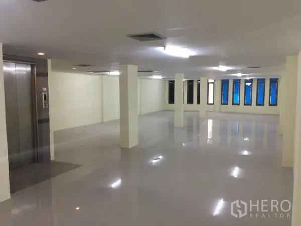 สำนักงานที่บ้าน ให้เช่าในWatthana, Bangkok - โถงทำงานกว้าง พร้อมเสารับน้ำหนัก ไฟฟลูออเรสเซนต์ แถวหน้าต่างยาว และโถงลิฟต์
