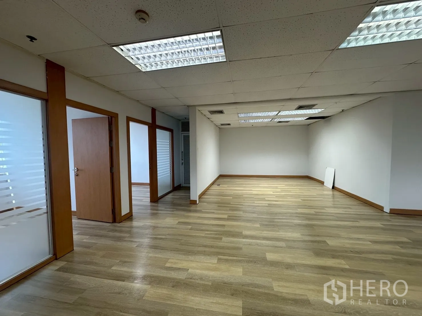 Office Space for rent - Corner team area beside hallway in neutral tones with recessed lighting.