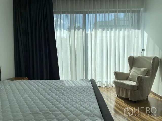 独栋房屋 for rent in Watthana, Bangkok - 卧室一角，翼背椅、床与透光窗帘。