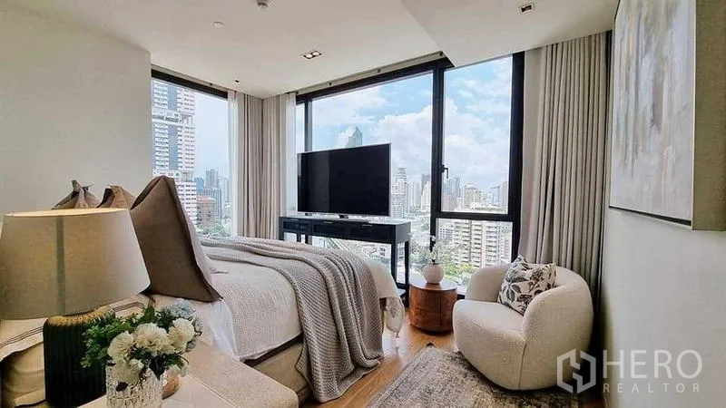 Condominium for sale - Primary bedroom with corner windows, city views and TV on a console.