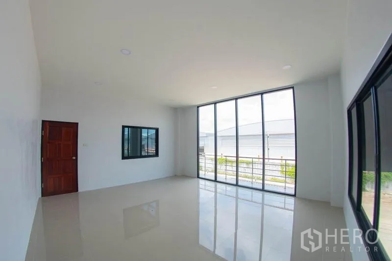 Warehouse for sale in Krathum Baen, Samut Sakhon - Bright upstairs office with floor-to-ceiling windows opening to a balcony.