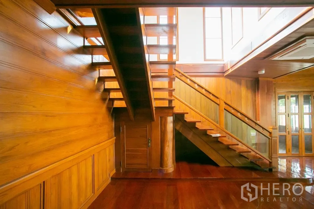 独栋房屋 for rent or sale in Huai Khwang, Bangkok - 木质楼梯与墙面细节，顶部高窗引入自然光。