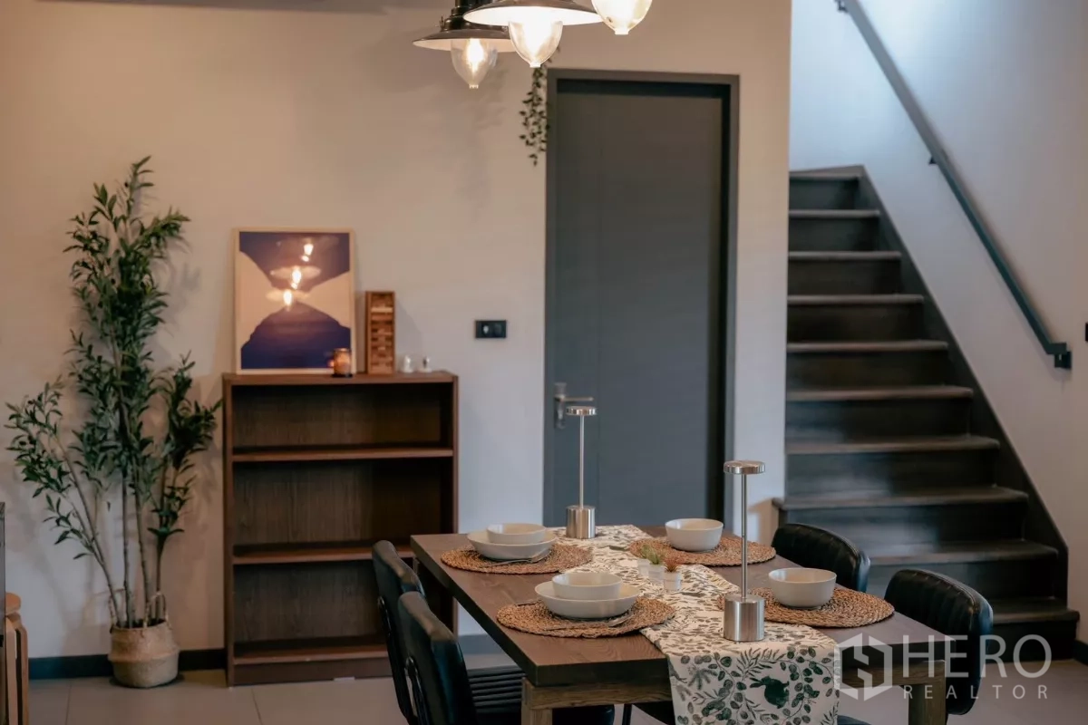 Detached House for rent or sale in Bang Phli, Samut Prakan - Dining zone with a six‑seat table, pendant lights and staircase to upper floor.