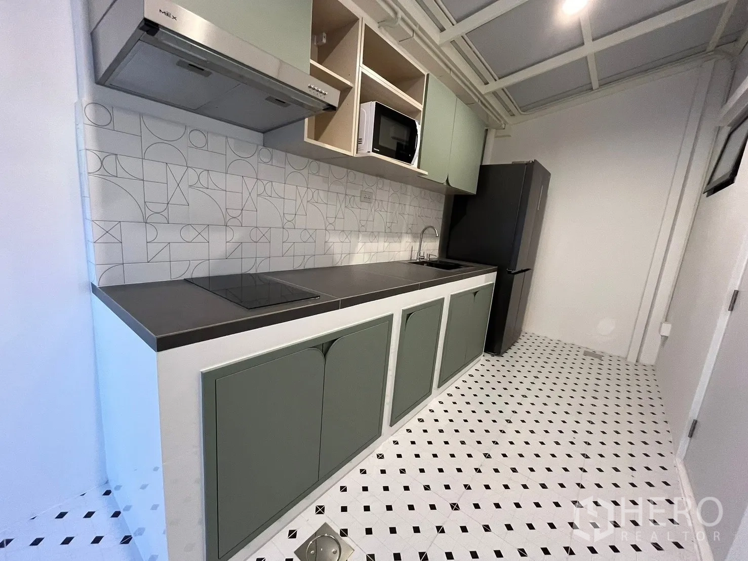 Townhouse for rent in Bang Phli, Samut Prakan - Built-in kitchen with mint cabinets, patterned backsplash, induction hob, hood, and fridge.